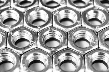 Arka planda metal somunlar. Krom vidalı somunlar izole. Çelik somun deseni. Somun ve cıvata seti. İş için araçlar. 