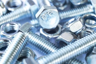 Bir satır arka planda metal cıvata ve somunlar. Krom vida cıvata ve somun izole. Çelik cıvata ve somun deseni. Somun ve cıvata seti. İş için araçlar.