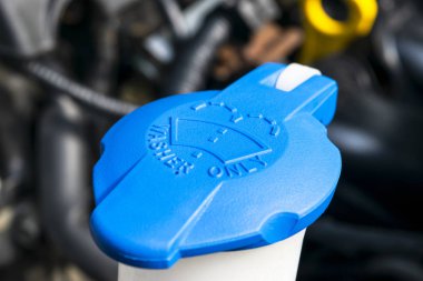 Araba ön cam silecek temizleme sprey su deposu mavi şişe kapağı araba motoru alanında. Araba detaylandırması. Araba içeride. Araba motoru yakınında kaputun altında ön yüklü.