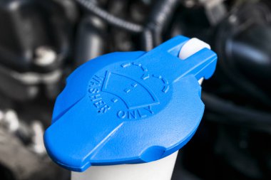 Araba ön cam silecek temizleme sprey su deposu mavi şişe kapağı araba motoru alanında. Araba detaylandırması. Araba içeride. Araba motoru yakınında kaputun altında ön yüklü.