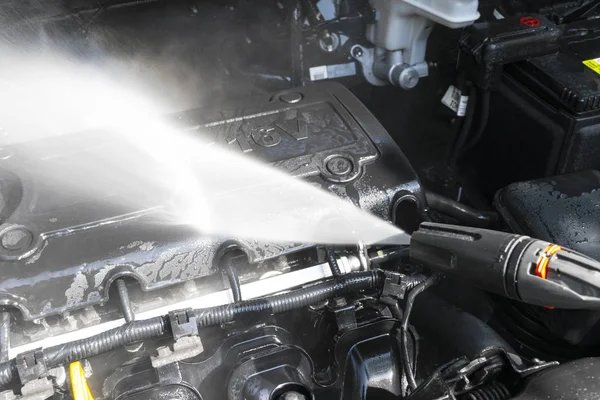 Car detailing. Manual car wash engine with pressure water. Washing car engine with water nozzle. Car washman worker cleaning vehicle. Man spraying pressure washer for car wash