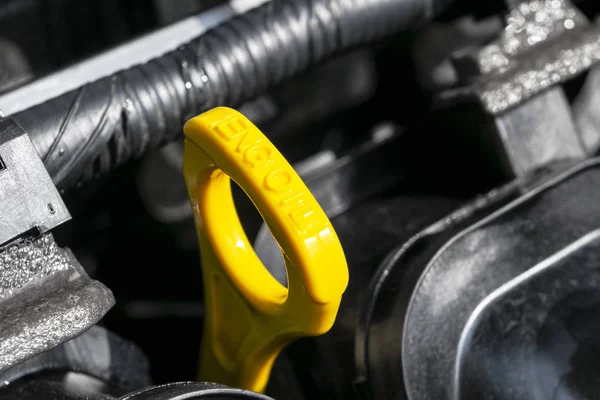 Żółty wskaźnik oleju w silniku samochodowym. Pomiar poziomu oleju silnikowego. Wskaźnik poziomu oleju na miarkę z żółtym kolorem do sprawdzania poziomu oleju silnikowego układu silnika. — Zdjęcie stockowe