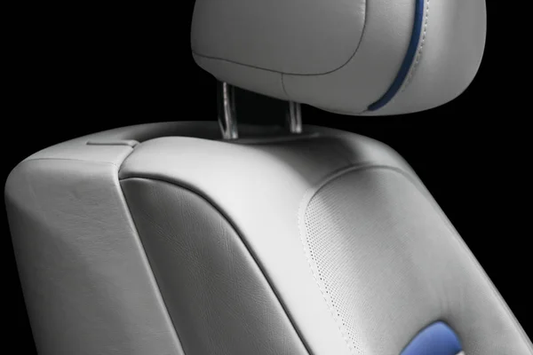 White leather interior of the luxury modern car. Perforated white leather comfortable seats with stitching isolated on black background. Modern car interior details. Car detailing. Car inside.