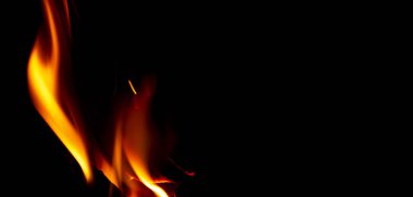 Ateş dokusu siyah arkaplanda izole edilmiş. Siyah arka planda yangın alevleri. Ateş şekilleri. Uzay boyunca alevlerin dokusu. Kırmızı alevler çok yakın. Alevli arka plan