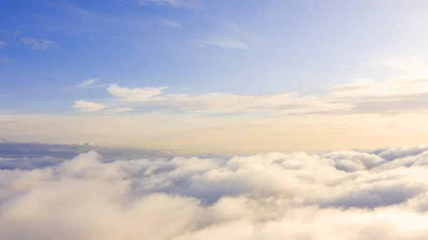 Aerial view White clouds in blue sky. Top view. View from drone.Aerial view White clouds in blue sky. Top view. View from drone. Aerial bird's eye view. Aerial top view cloudscape. Texture of clouds. View from above. Sunrise or sunset over clouds