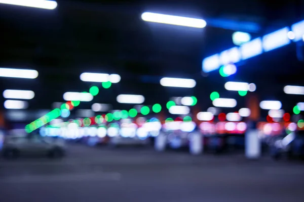 Blurred cars in car parking lot in shopping mall. Bokeh lights background. Abstract blur car parking lot for background. Blurred cars parking and bokeh light — Stock Photo, Image