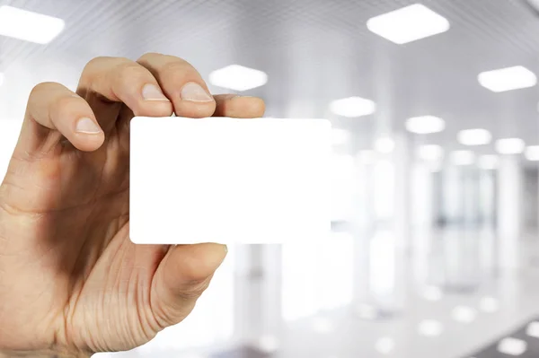 Homme d'affaires tenant une carte de visite vide vierge avec écran blanc isolé. Homme d'affaires présentant sa carte de visite. Il tient une carte blanche. Carte de visite blanche à la main avec chemin de coupe sur la carte . — Photo