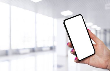 İş merkezi geçmişi olan kadın eli akıllı telefon modeli. Modern çerçevesiz akıllı telefon boş beyaz ekran ile taklit edilir. Metin için boş alan. Uzayı kopyala İzole edilmiş beyaz ekran.