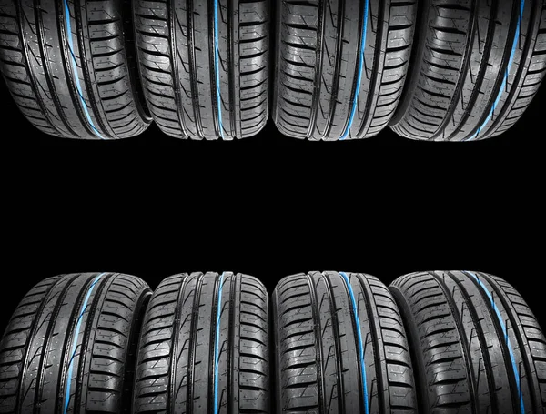 Studio shot of a set of summer car tires on black background. TiStudio shot of a set of summer car tires on black background. Tire stack background. Car tyre protector close up. Black rubber tire. Brand new car tires. Close up black tyre profile. Car — Stock Photo, Image