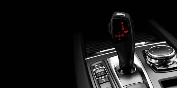 Black Automatic gear stick of a modern car. Modern car interior details. Close up view. Car detailing. Automatic transmission lever shift isolated on black background. Black leather interior with stitching. — Stock Photo, Image