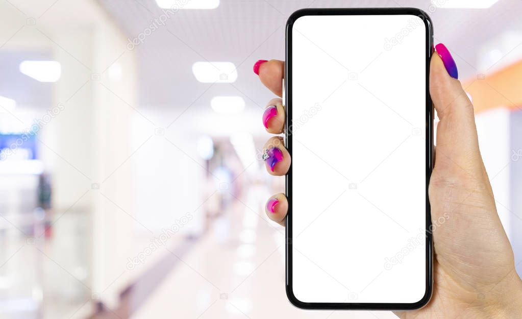 Smartphone mockup in woman hand with business centre background. Modern frameless smartphone mock up with blank white screen. Empty space for text. Copy space. Isolated white screen.