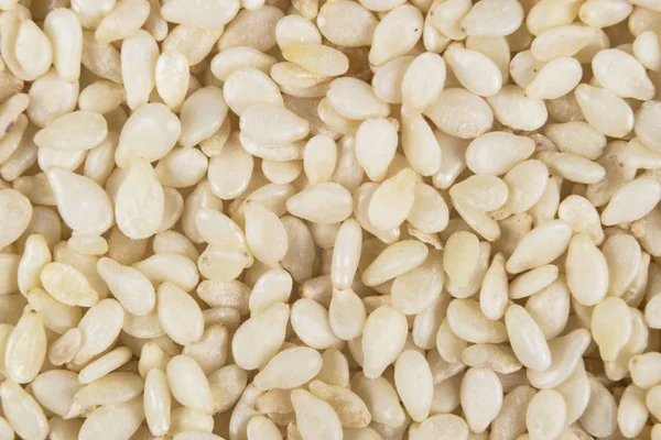 Makroaufnahme eines rohen weißen Sesamhintergrundes. Ansicht von oben. Lebensmittel-Hintergrund. eine Verstreuung von Sesam. Gesunde Ernährung. Natürliche Lebensmittel. — Stockfoto