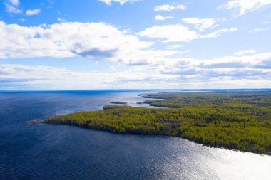 Hava manzaralı yaz ormanı ve göl. Üst Manzara. İHA 'dan kıyı şeridi görüntüsü. Üst hava manzarası bulutlu. Bulutların dokusu. Yukarıdan bak. Üst görünüm su yüzeyi