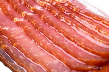 Makro beyaz arka planda izole edilmiş birkaç sıra doğranmış pastırma vurdu. Beyaz arka planda izole edilmiş taze dilimlenmiş pastırma. Çiğ, kurutulmuş domuz pastırması..