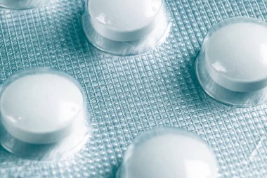 Makro şişkinlik ambalajında hap yığını. Gümüş alüminyum folyo su topladı. İlaç sanayisi. Eczane ürünleri. İlaç hapları ve uyuşturucular kapanıyor. Sağlık hizmetleri. Haplar arka plan