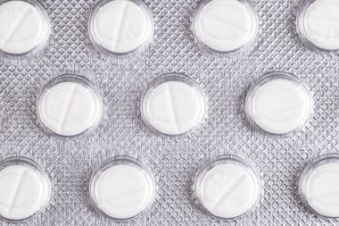 Makro şişkinlik ambalajında hap yığını. Gümüş alüminyum folyo su topladı. İlaç sanayisi. Eczane ürünleri. İlaç hapları ve uyuşturucular kapanıyor. Sağlık hizmetleri. Haplar arka plan