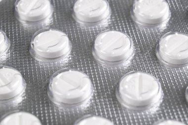 Makro şişkinlik ambalajında hap yığını. Gümüş alüminyum folyo su topladı. İlaç sanayisi. Eczane ürünleri. İlaç hapları ve uyuşturucular kapanıyor. Sağlık hizmetleri. Haplar arka plan
