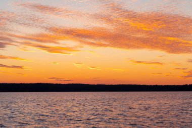 Su yüzeyi. Sunset gökyüzü arkaplanının görüntüsü. Deniz üzerinde akşam gökyüzü bulutları ile dramatik altın gün batımı gökyüzü. Kristal berrak deniz suyu dokusunun görüntüsü. Manzara. Küçük dalgalar. Su yansıması