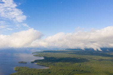 Orman ve denizin üzerindeki hava manzaralı bulutlar. İnsansız hava aracı görüntüsü. Üst hava manzarası bulutlu. Bulutların dokusu. Yukarıdan yeşil ormanı izle.