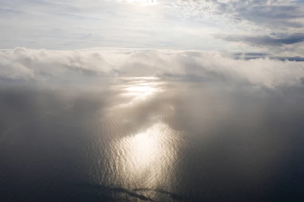 Aerial view clouds over the sea. View from drone. Aerial top view cloudscape. Texture of clouds. View from above. Sunrise or sunset over clouds. Aerial ocean background