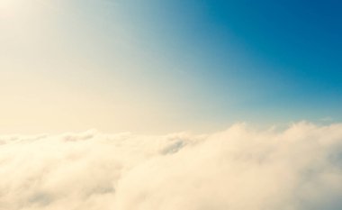 Mavi gökyüzünde hava manzaralı beyaz bulutlar. İnsansız hava aracı görüntüsü. Üst hava manzarası bulutlu. Bulutların dokusu. Yukarıdan bak. Bulutların üstünde gün doğumu ya da gün batımı. Panorama bulutları