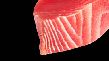 Siyah arka planda sarı yüzgeçli ton balığı bifteği. Siyah üzerine izole edilmiş taze ton balığı bifteği. Çiğ sarı yüzgeçli ton balığı filetosu. Arka planda taze ton balığı eti. Dilimlenmiş ton balığının üst görüntüsü.