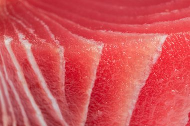 Makro sarı yüzgeçli ton balığı bifteği vurdu. Taze, az pişmiş ton balığı bifteği. Çiğ sarı yüzgeçli ton balığı filetosu. Arka planda taze ton balığı eti. Ton balığı eti dilimleri.