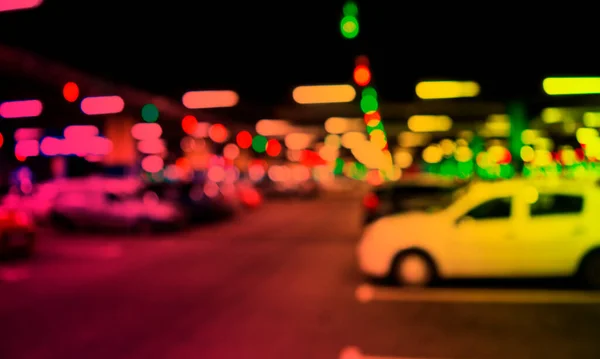 Blurred cars in car parking lot in shopping mall. Bokeh lights background. Abstract blur car parking lot for background. Blurred cars parking and bokeh light concept