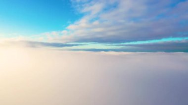 Bulutlardan gökyüzüne doğru hareket halindeki hava görüntüsü. Güneş doğarken ya da batarken mavi gökyüzünde beyaz bulutlar. Hava bulutları. Bulutların dokusu. Panoramik manzara. Bulutlar hareket halinde