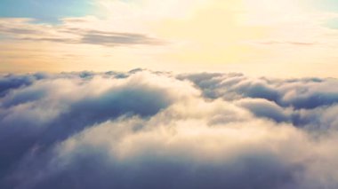 Gün batımında bulutlarla kaplı güzel bir turuncu gökyüzü. Mavi gökyüzü ile beyaz bulutların zamanı. Hareket eden bulutların arasından uçmak. Bulutların dokusu. Panoramik manzara. Bulutlar hareket halinde