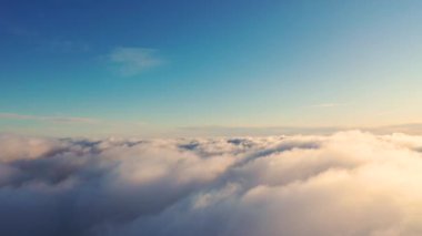 Gün batımında bulutlarla kaplı güzel bir turuncu gökyüzü. Mavi gökyüzü ile beyaz bulutların zamanı. Hareket eden bulutların arasından uçmak. Bulutların dokusu. Panoramik manzara. Hareketli bulutlar
