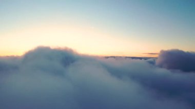 Gün batımında bulutlarla kaplı güzel bir turuncu gökyüzü. Mavi gökyüzü ile beyaz bulutların zamanı. Hareket eden bulutların arasından uçmak. Bulutların dokusu. Panoramik manzara. Bulutlar hareket halinde