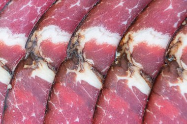 Tütsülenmiş domuz salamı sucuk sosislerinin üst görüntüsü arka planda. Makro çiğ tütsülenmiş salam deseni