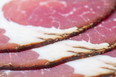 Tütsülenmiş domuz salamı sucuk sosislerinin üst görüntüsü arka planda. Makro çiğ tütsülenmiş salam deseni