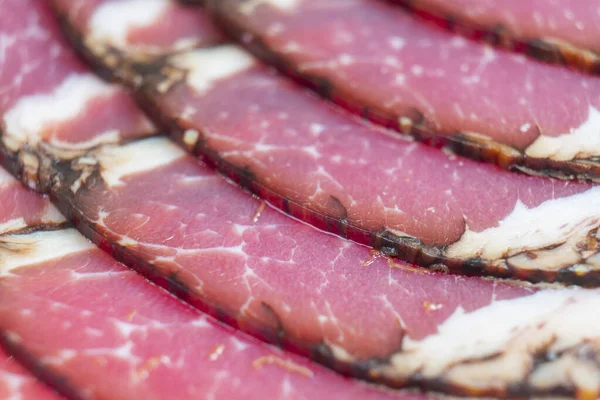 Top view of smoked pork salami chorizo sausages slices background. Macro shot raw smoked salami pattern