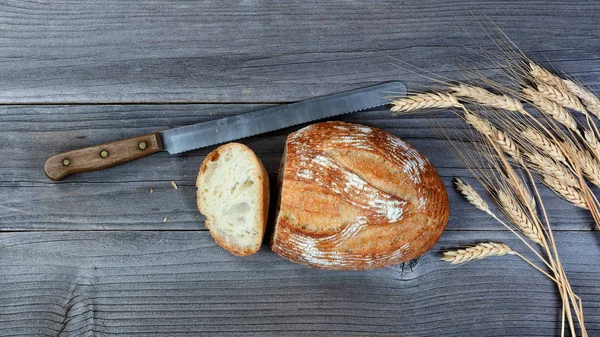 用切刀和小麦秸秆烘烤整条面包的开销视图在乡村木板上 — 图库照片
