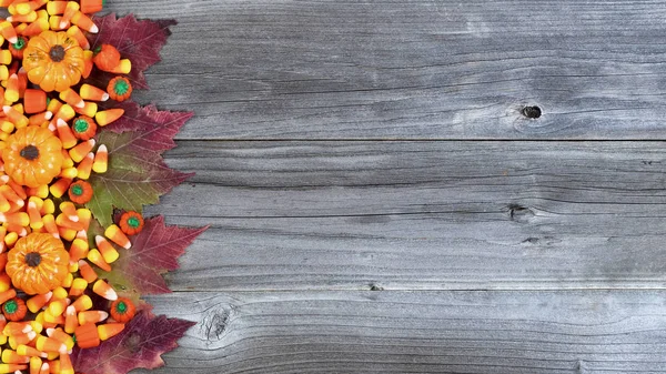 万圣节糖果的左边界和在乡村木板上的秋季装饰品 — 图库照片