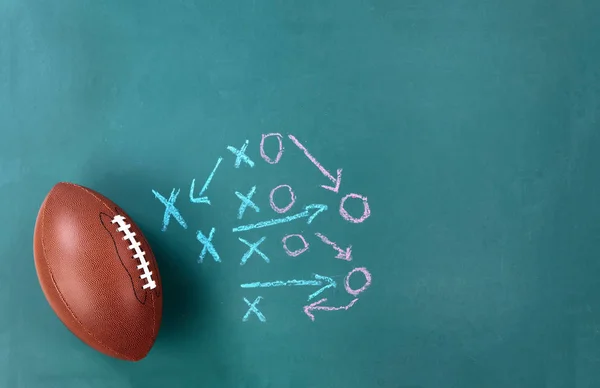 American football with game plan on cleaned chalkboard