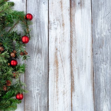 Herdem yeşil dallar ve rustik ahşap beyaz kırmızı süsler ile Noel arka plan 