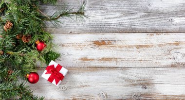 Zor bir çam dalları ile Noel top süsler ve giftbox rustik beyaz ahşap kurullarında 