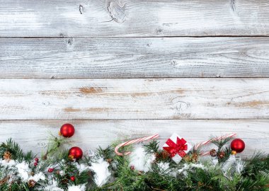 Evergreen dalları ile diğer tatil dekorasyon beyaz rustik ahşap üzerine alt kenarlık Noel kar kaplı