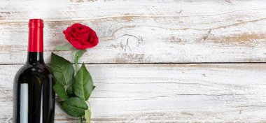 Romantik Sevgililer günü kutlama kırmızı şarap ve beyaz rustik ahşap üzerine tek bir gül ile 