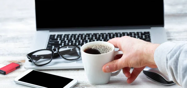 男性手伸手去拿一杯咖啡与工作站技术 — 图库照片
