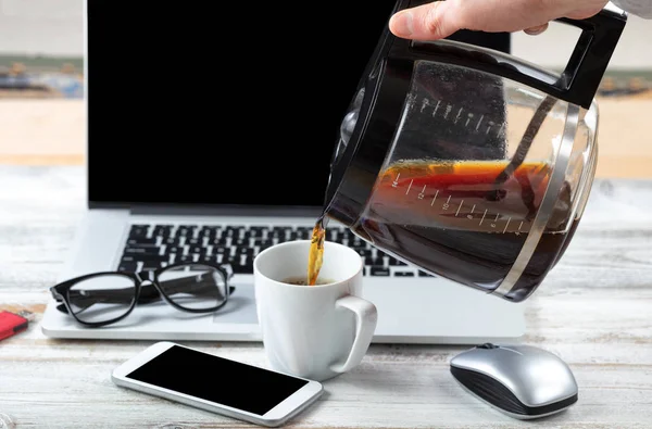 Masculino mão fulling copo até com café com estação de trabalho tecnologia — Fotografia de Stock