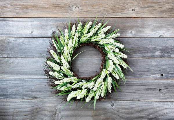 Natuurlijke bloemkrans op verweerde houten achtergrond — Stockfoto