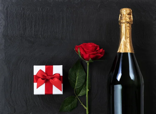 Anniversary background with champagne and gifts on natural slate — Stock Photo, Image