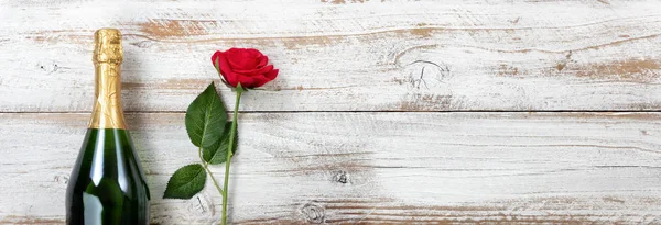Výročí pozadí s červenou růží a šampaňským na bílém weat — Stock fotografie
