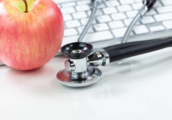 Medical health care concept with stethoscope and apple in backgr