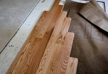 Kontrplak döşeme ve yeni kırmızı meşe tahtaları olan eski halı yenileniyor.