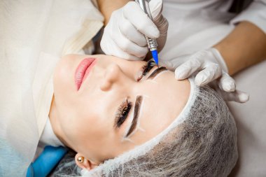 Kalıcı makyaj kaşları için. Güzel kadının güzellik salonu içinde kalın kaşları ile portre. Şevval özçelik güzellik kadın yüzü için kaş dövme yapıyor. Güzellik yordamı.